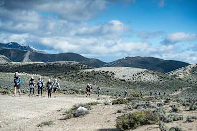 Competitors hike along a dusty road in Race the Planet, Patagonia.