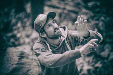 Profikletterer Kilian Fischhuber geht eine Kletterroute vom Boden aus im Kopf durch.