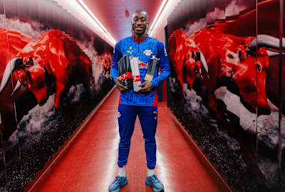 Yan Diomande zeigt im Spielertunnel von RB Leipzig stolz seine Saison-Awards.