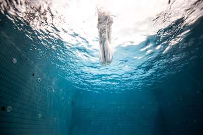 A cliff diver enters the water at high speed following a dive from 27m.