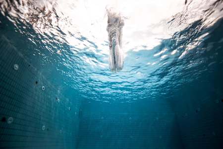A cliff diver enters the water at high speed following a dive from 27m.