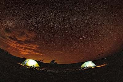Bikes and tents seen under the stars in Kenya.