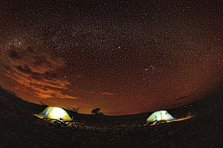Bikes and tents seen under the stars in Kenya.