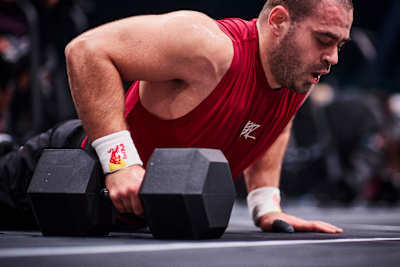 Luka Đukić on the floor with a dumbbell during the World Fitness Project Finals 2025 in Copenagen, Denmark.