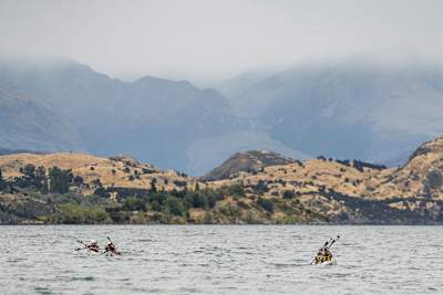 Kayakers cross a lake in New Zealand.