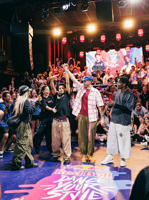 Orion celebra haber ganado la final nacional del Red Bull Dance Your Style de España, celebrada en Barcelona el 5 de septiembre de 2026, rodeado de bailarines y aficionados que le animaban.