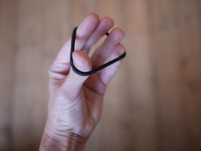 Ejercicios de movimiento de los dedos con una goma del pelo.