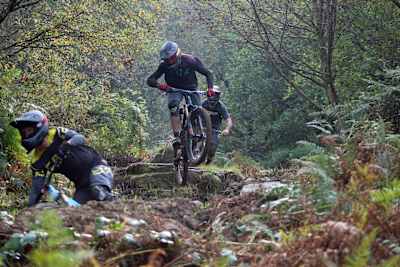 MTB riders navigate the Root Manoeuvres trail at BikePark Wales.