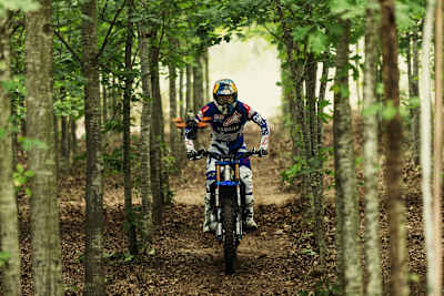Tom Pagès riding his motorbike in the forest.