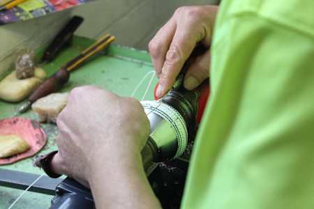 An expert works on the white Kookaburra cricket ball in the factory.