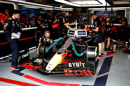 Members of the Oracle Red Bull Racing team work on the car before the start of a race. 