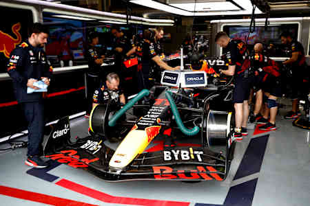 Members of the Oracle Red Bull Racing team work on the car before the start of a race. 