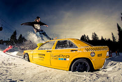A snowboarder slides over a taxi parked in the snow on the mountain in Nesselwang in the Allgäu. 