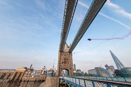 Red Bull wingsuiter flying through Tower Bridge in London.