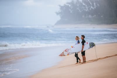 Molly Picklum und Glenn Hall bereiten sich auf das Surfen am Sunset Beach in Hawaii vor. 