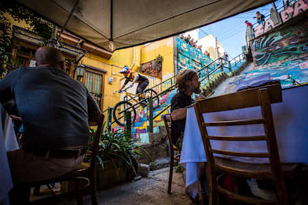 Tomas Slavik rides past a kerbside cafe during the 2019 Red Bull Valparaiso Cerro Abajo in Valparaiso, Chile.
