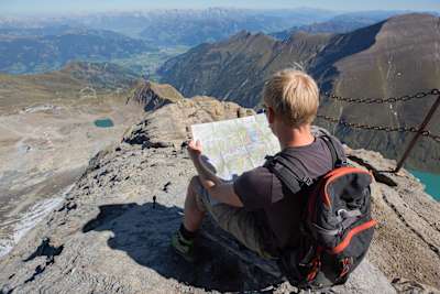 Person sat reading a map at the top of a mountain in Austria.