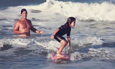 Caroline Marks surfs under the watchful eye of father Darren