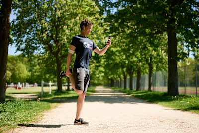 Philipp Hansa s'étire l'avant de la cuisse pendant la course sur l'application de la Wings For Life World Run.