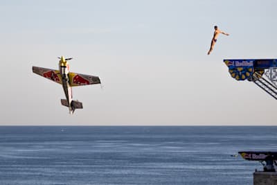 Dario Costa flies by as Aidan Heslop makes his dive in the Volare Duet - the first ever synchronised aerobatic flight and cliff dive.