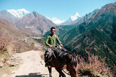 A Sherpa rides past on a horse