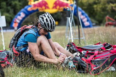 Competitor ties shoes during an adventure race.