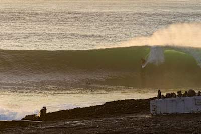 Profi-Surfer Kanoa Igarashi surft in Coxos eine großen Welle ab.