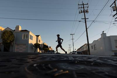 Silhouette of Rickey Gates running through a San Francisco suburb.