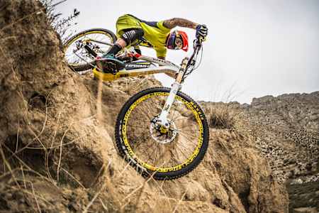 Rider on an e-bike goes down a sandy chute.