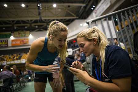 Leah Crane shows Shauna Coxsey video footage of a climb on the sidelines of a competition.
