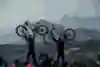 Competitors hold up their bikes in celebration.