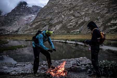 Ultrarunners attempt to keep themselves warm on the UTMB course