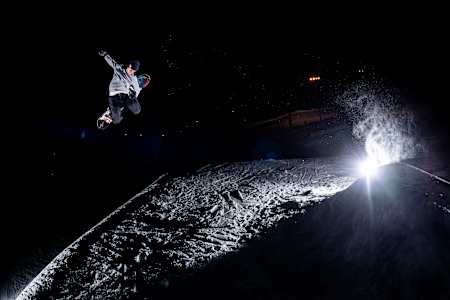 Benny Milam does a backside 180 tuckknee during a photoshoot at Trollhaugen