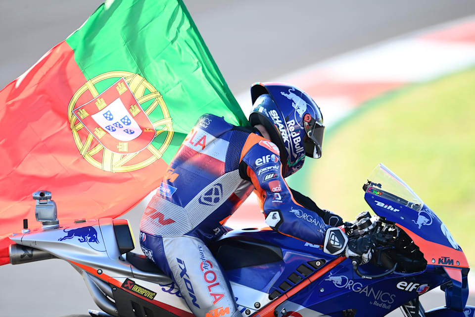 KTM rider Miguel Oliviera rides around the track carrying his national flag.