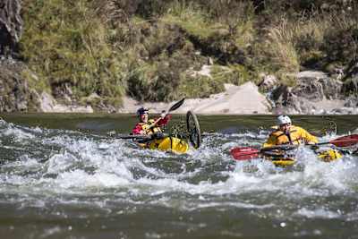 Rob Warner y Matt Jones en kayak con sus bicis en el Buller District de Nueva Zelanda.