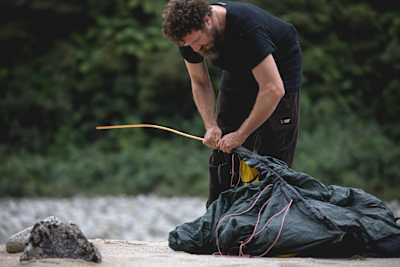 Josh James preps a tent for Rob Wild Rides crew at their wilderness camp in the Buller District of New Zealand.