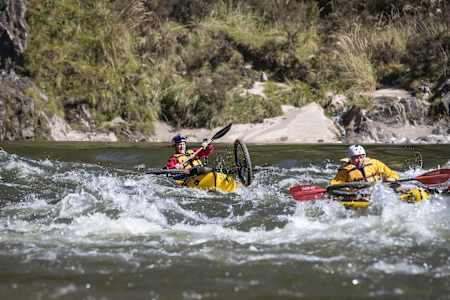 Rob Warner and Matt Jones participate in kayaking with their bikes in the Buller District of New Zealand.