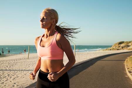 Kobieta biegnie po plaży