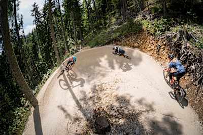 Riders rail a berm in Carinthia, Austria during a mountain bike ride.