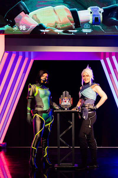 Zwei Cosplayer, die als VALORANT-Agenten verkleidet sind, posieren beim Red Bull Home Ground National Finals Event in Amsterdam.