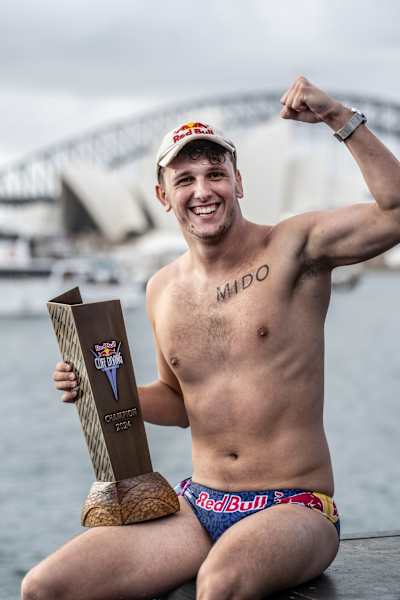 Aidan Heslop celebrates his victory at the Red Bull Cliff Diving World Series 2024 final in Sydney, showcasing determination and athleticism with the iconic Harbour Bridge as a backdrop