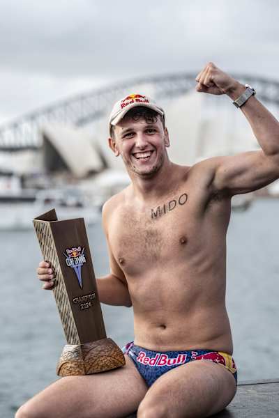 Aidan Heslop feiert seinen Sieg beim Finale der Red Bull Cliff Diving World Series 2024 in Sydney und zeigt dabei Entschlossenheit und Athletik vor der Kulisse der ikonischen Harbour Bridge
