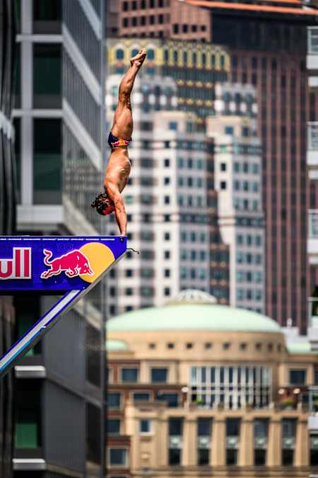 Im Jahr 2024 springt Cătălin Preda bei der Red Bull Cliff Diving World Series von einem Gebäude in Boston. 