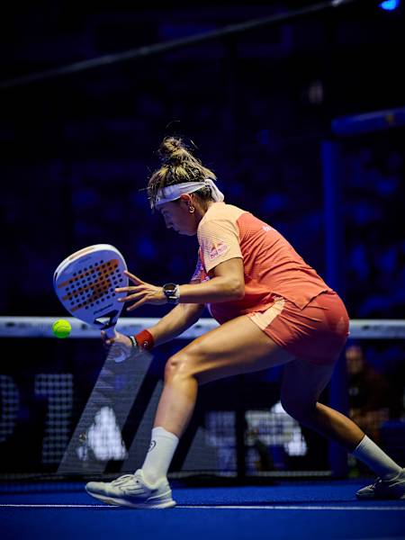 Beatriz González strikes a low volley during the 2026 Premier Padel P1 Madrid semi-final in Spain, wearing Red Bull kit under the arena lights