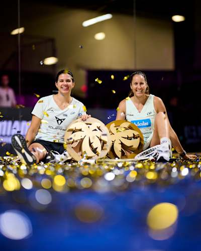 Delfina Brea y Gemma Triay celebran su triunfo en el torneo Motorola Razr Miami Premier Padel P1 en Miami, EE.UU., 2025, sosteniendo sus trofeos de ganadoras en medio de un ambiente festivo.