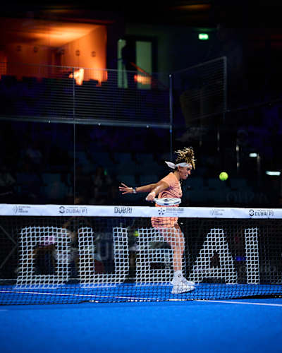 In November 2025, Beatriz González leaps into action during the Premier Padel P1 semi-finals on the vibrant blue court in Dubai, United Arab Emirates