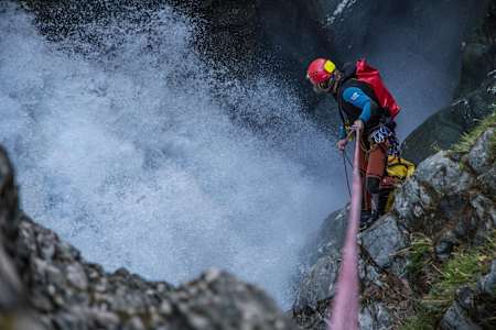A canyoner takes an abseil down into the depths of rushing water in a canyon in Wanaka, New Zealand.