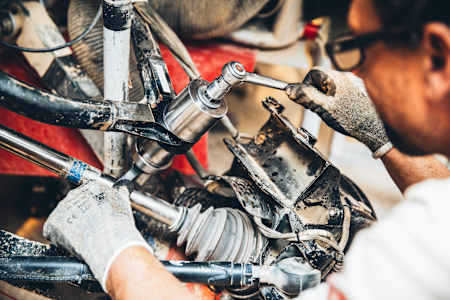 Un mécanicien du team Peugeot entretien les suspensions d'un véhicule du rallye Dakar à Erfoud.