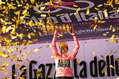 Primož Roglič dans le maillot rose de leader célèbre au podium avec le Trofeo Senza Fine comme vainqueur final de la course globale lors de la 106e Giro d'Italia 2023. 