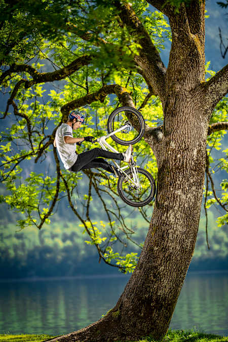 Trials biker Fabio Wibmer performs a stunt on a tree during a photoshoot for The Red Bulletin in Austria.